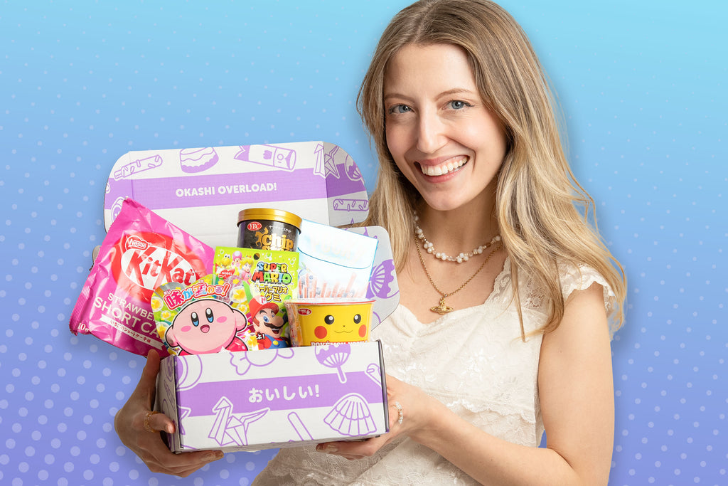 Woman holding a box of Japanese snacks against a blue background